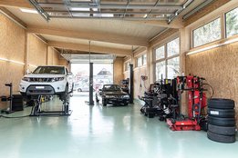 Innenaufnahme des Pneucenters der Garage Jost GmbH in Pieterlen mit Suzuki auf dem Wagenheber.